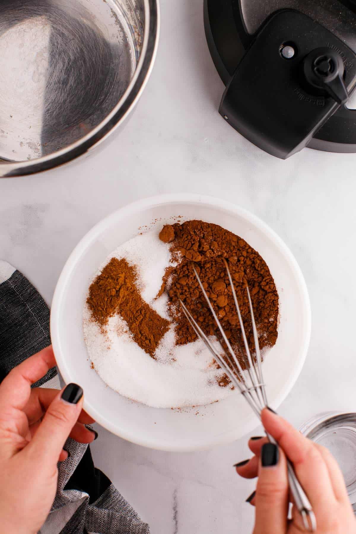 Dry hot cocoa ingredients to be mixed in a bowl with a whisk.