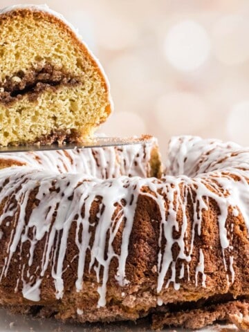 A cinnamon streusel filled sour cream coffee cake with glaze drizzled.