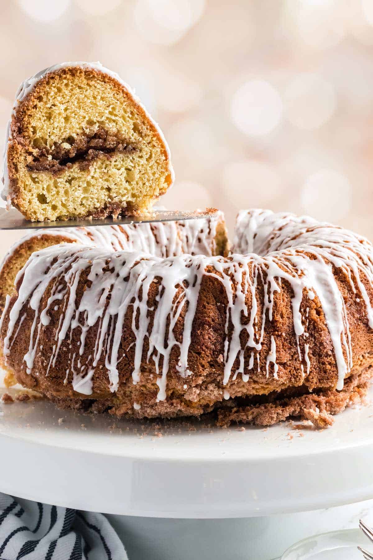 Sour cream bundt cake with a wedge cut out showing a cinnamon brown sugar filling.