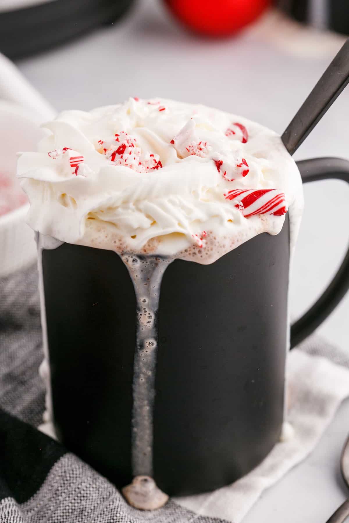 Whipped cream topped hot chocolate with peppermint pieces crumbled on top.