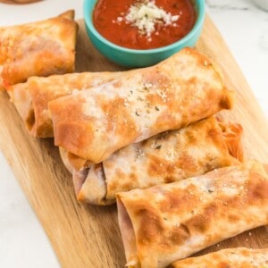 A stack of pizza rolls with marinara sauce.