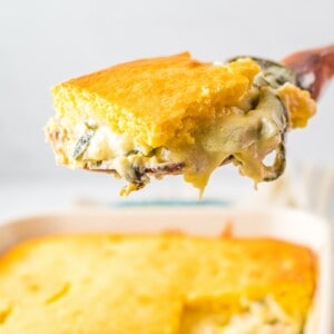 A slice of chile rellenos casserole with cheese and poblano peppers.