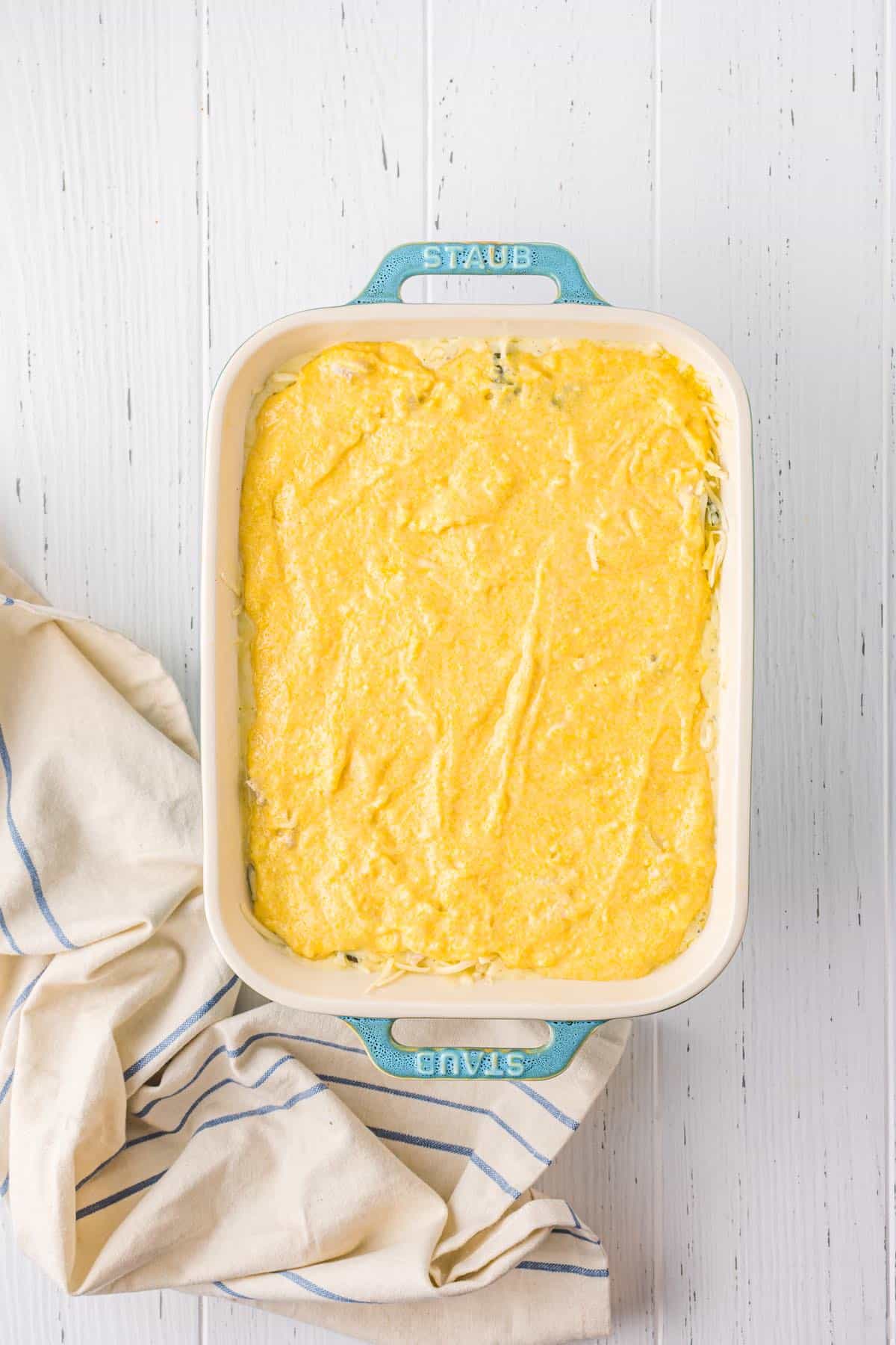 Cornbread mixture spread in a casserole dish.