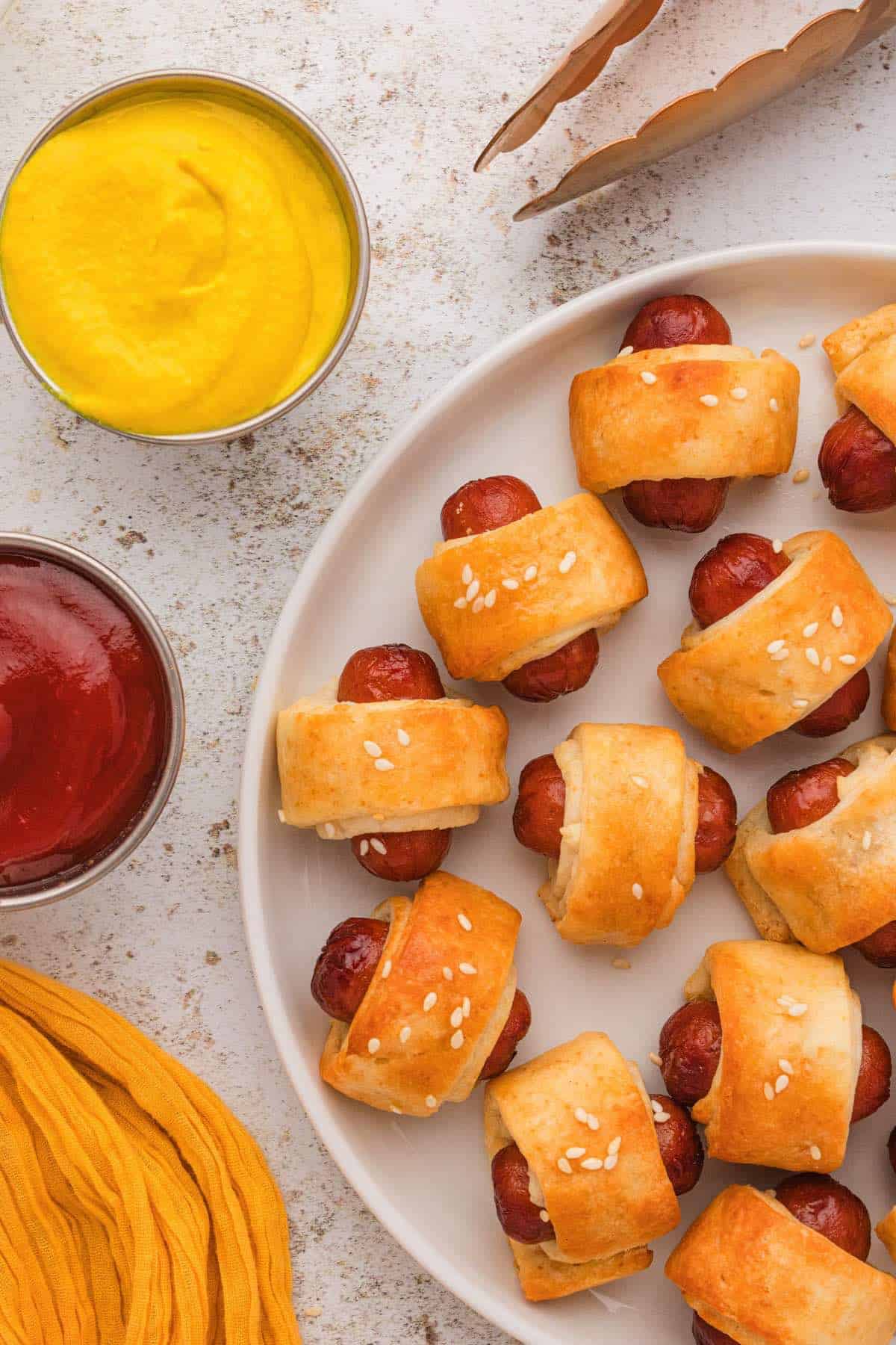 Pigs in a blanket with mustard and ketchup.