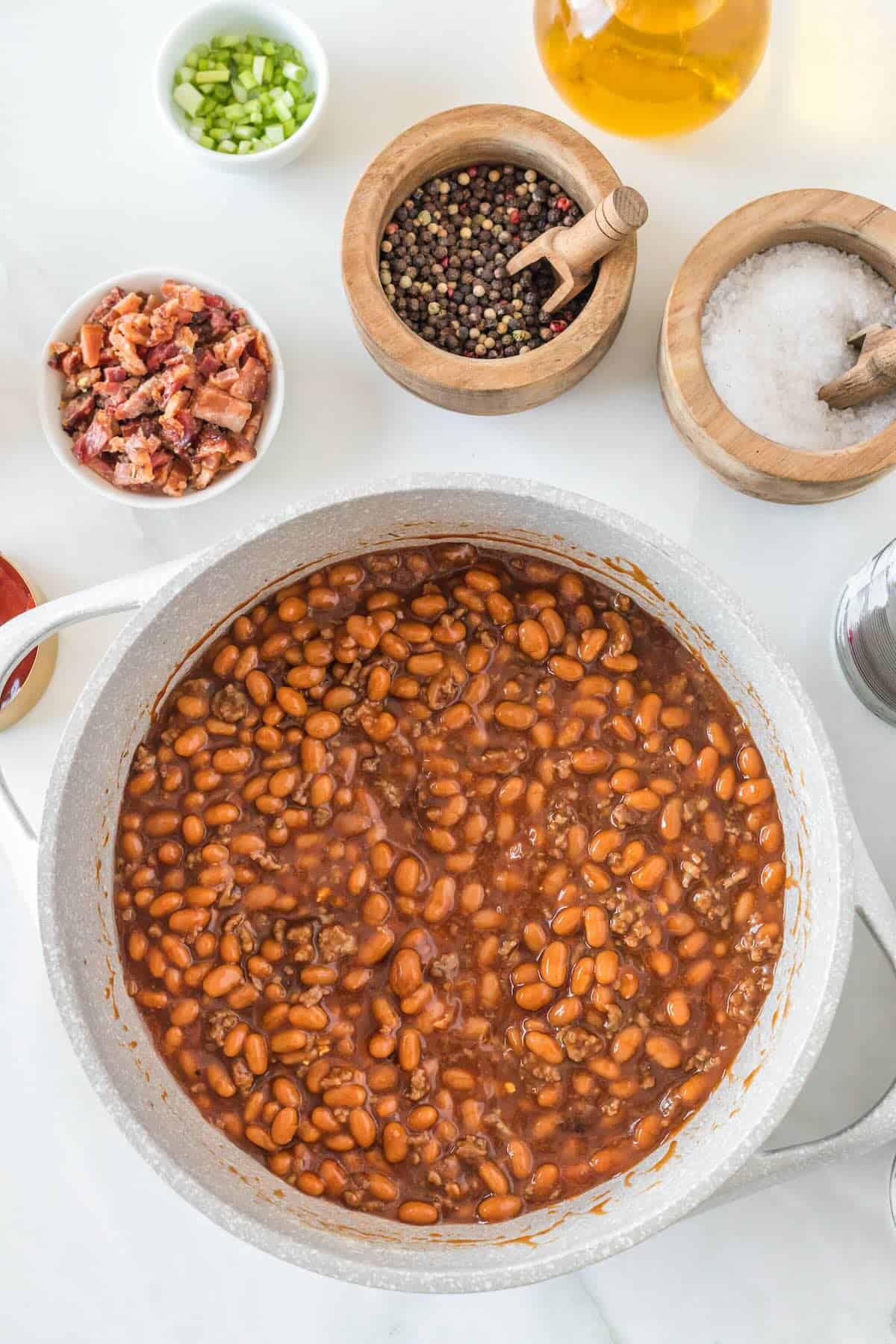 Cooked baked beans in a large pot with bacon.