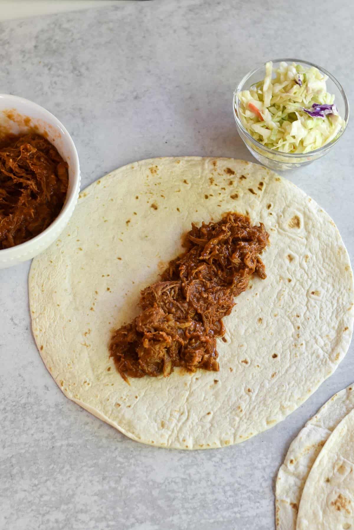 Pulled pork on a large flour tortilla.