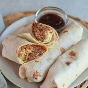 A stack of pulled pork wraps with one of them cut in half.
