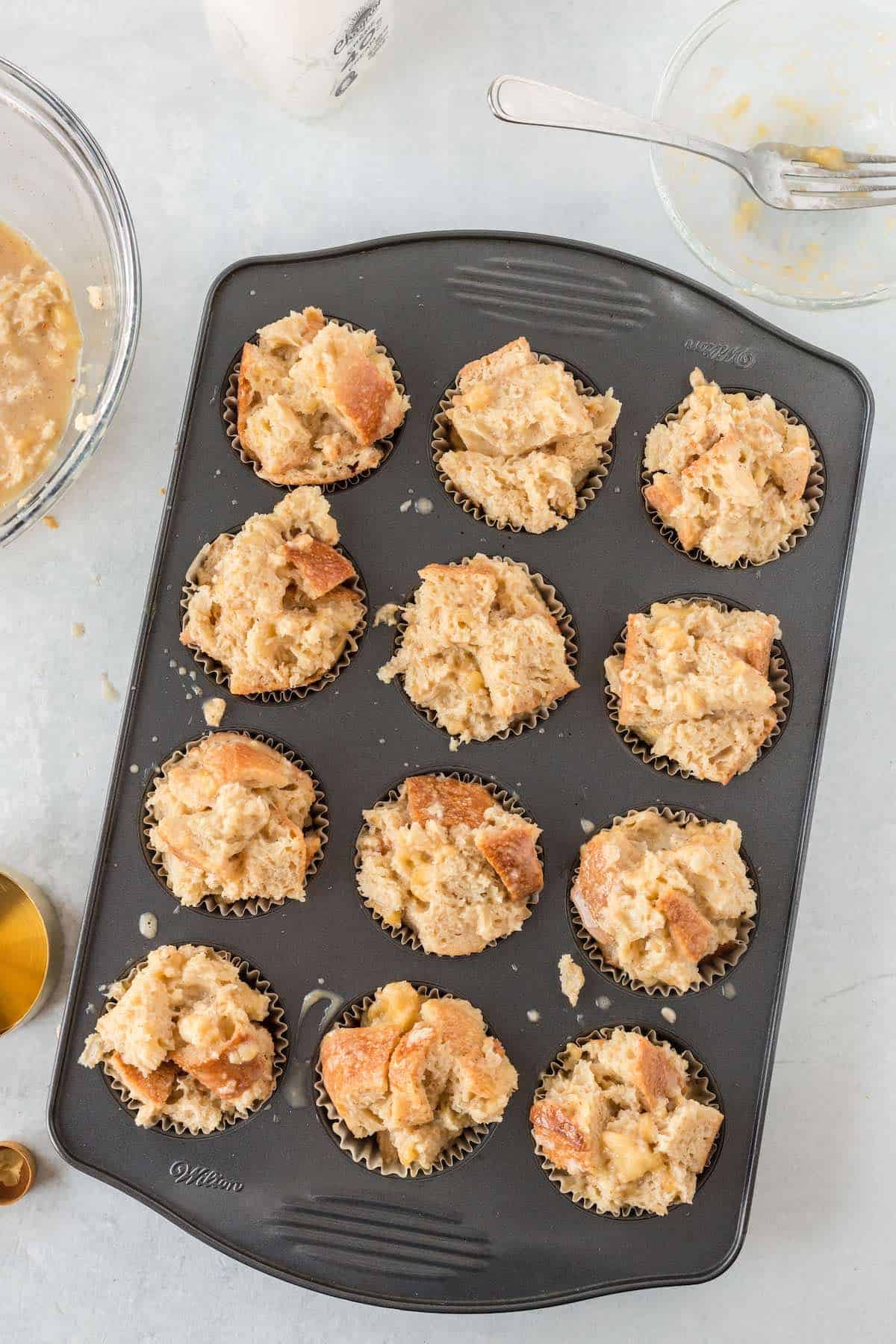Unbaked French toast cups in a muffin tin.