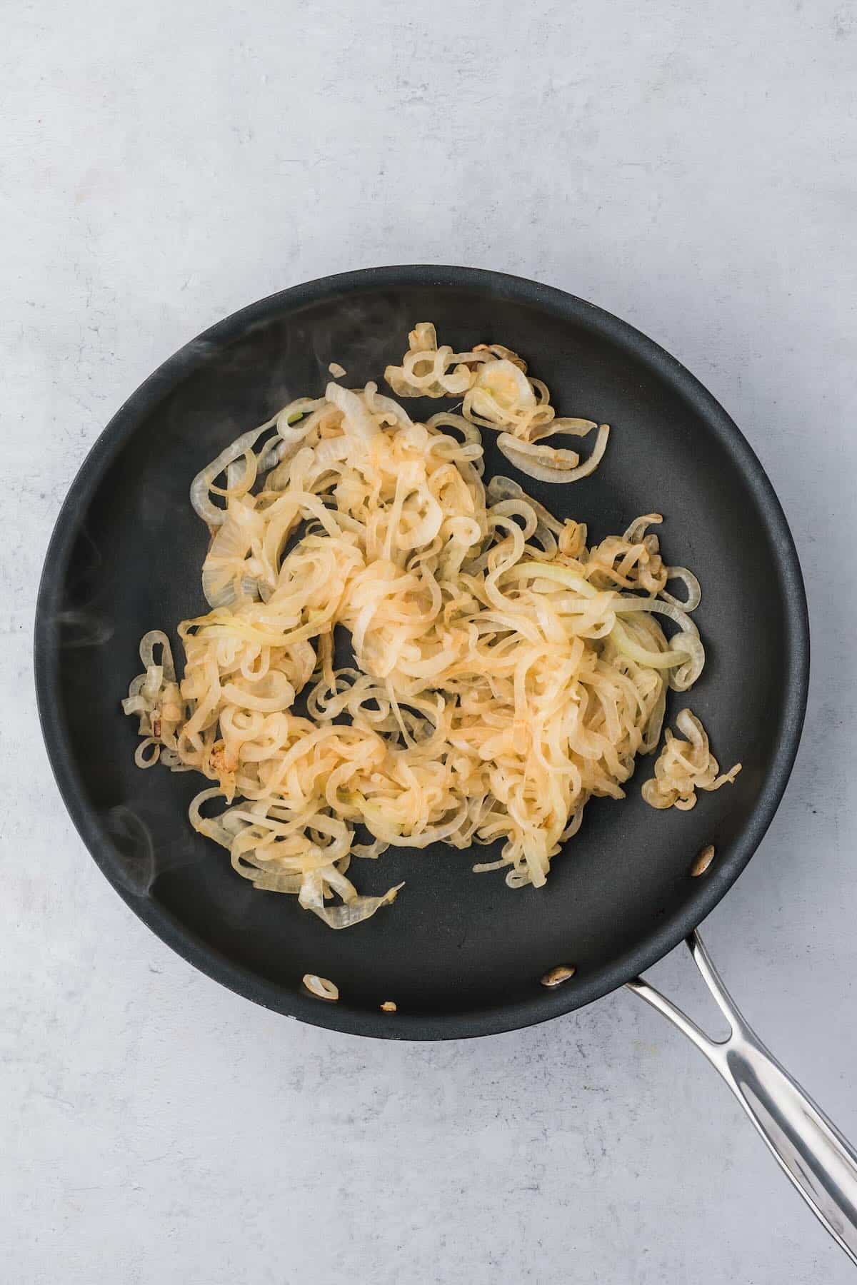 Caramelized and lightly browned onions in a skillet.