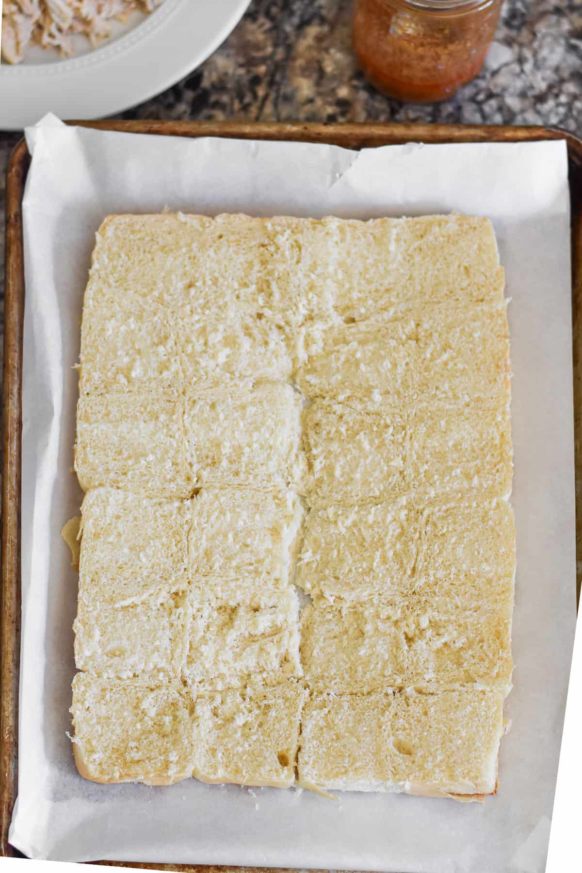 A package of Hawaiian rolls sliced in half.