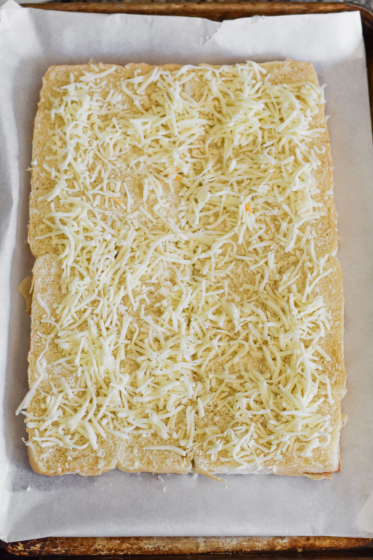 Hawaiian rolls topped with shredded Mozzarella cheese.