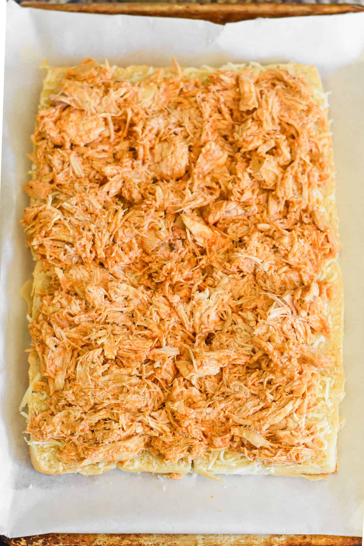 Shredded buffalo chicken spread on slider buns.