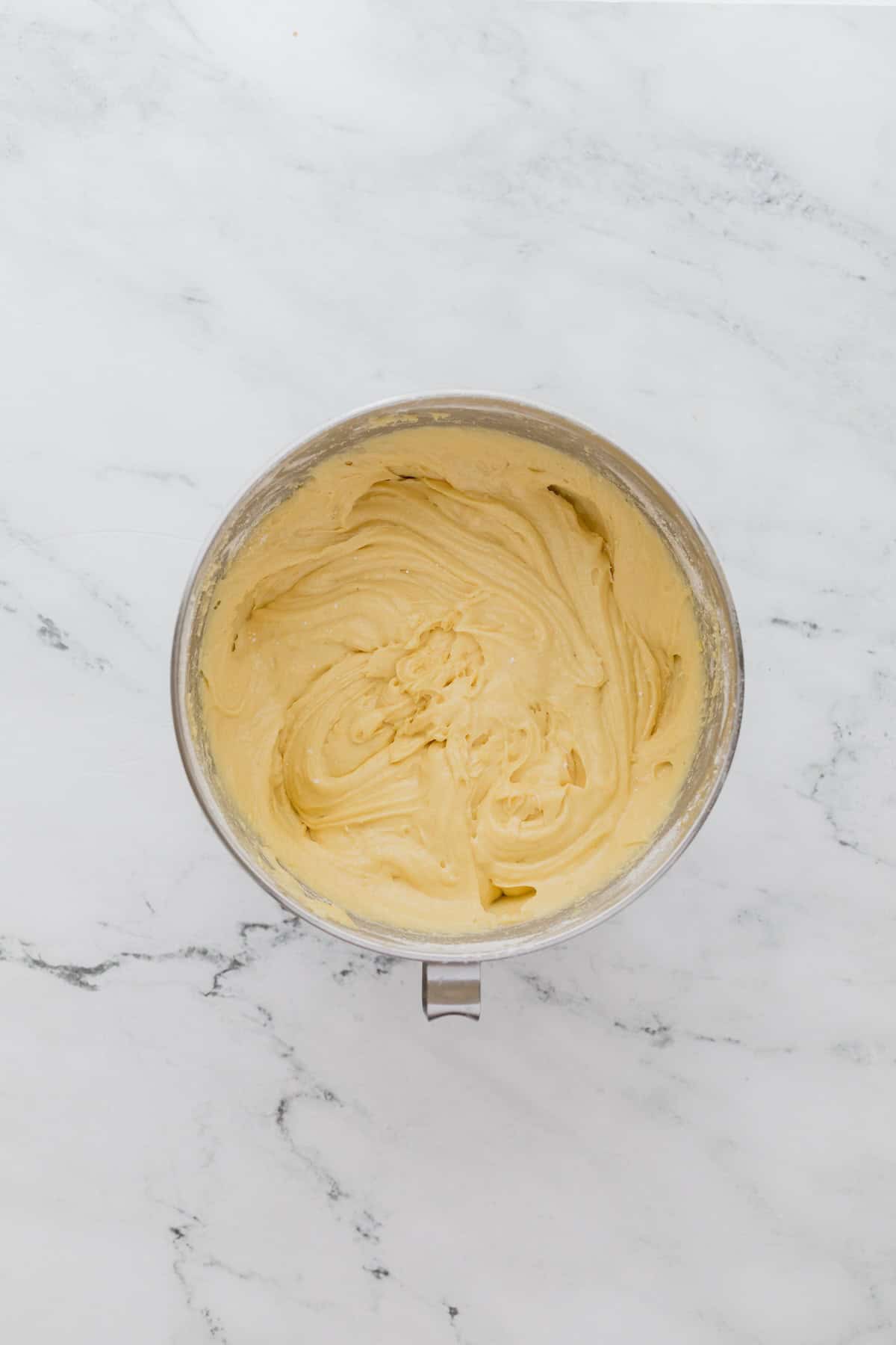 A bowl of light yellow cake batter after mixing.