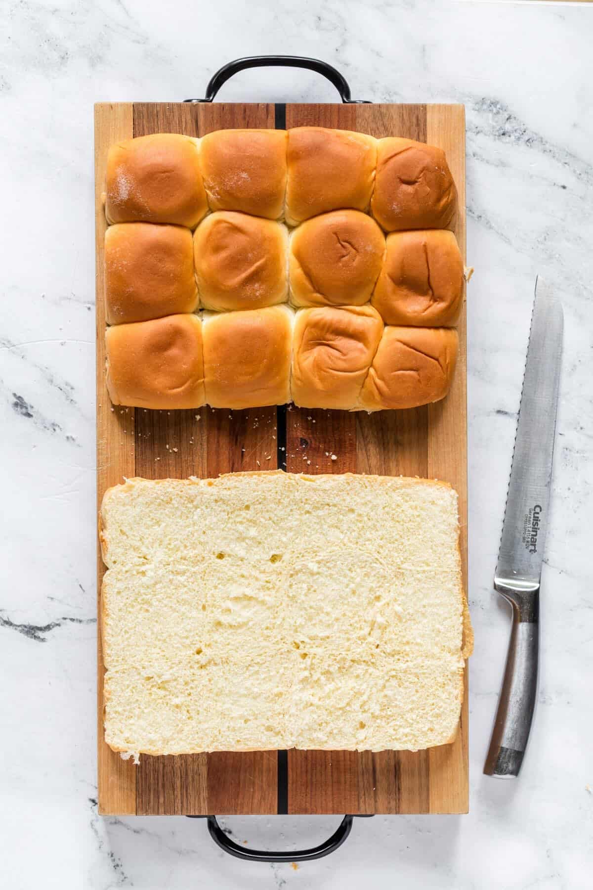 Hawaiian rolls sliced in half on cutting board ready for funeral sandwiches.