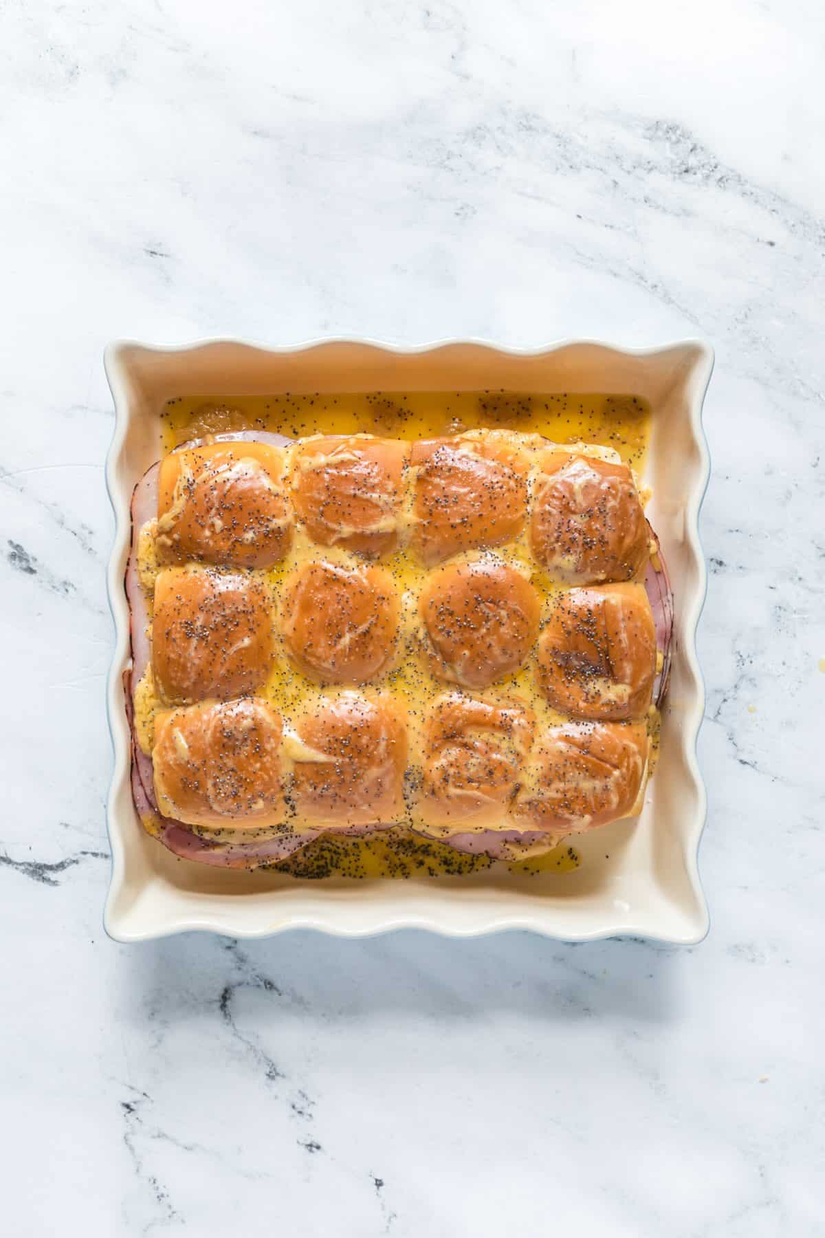 Buttery mustard sauce poured over funeral sandwiches with poppy seeds.