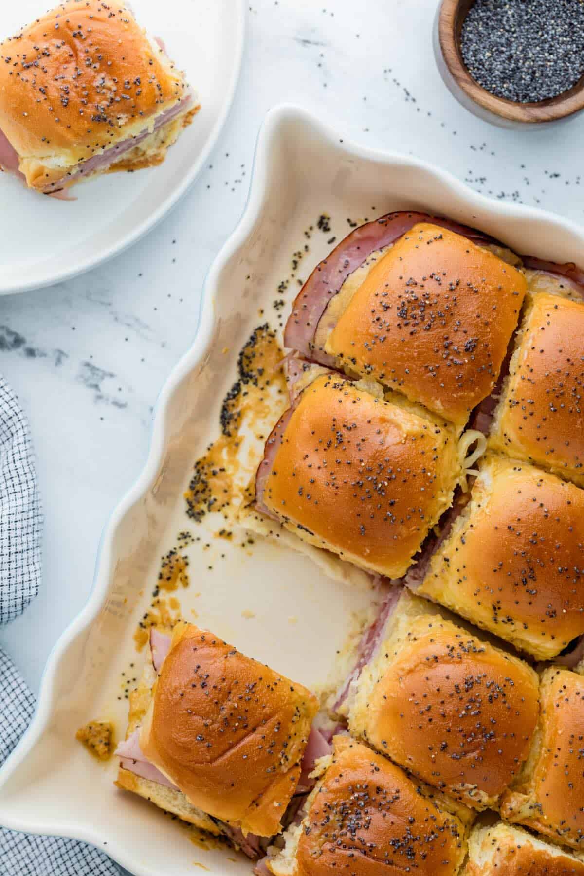 Fresh baked ham and Swiss cheese funeral sandwiches in casserole dish.