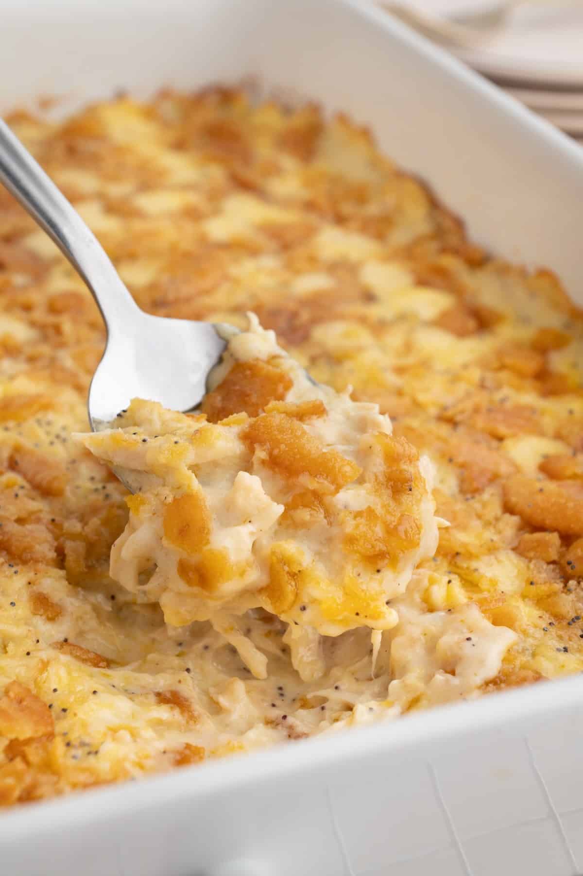 Poppy seed chicken casserole served family-style with rice and green beans for an easy weeknight dinner.