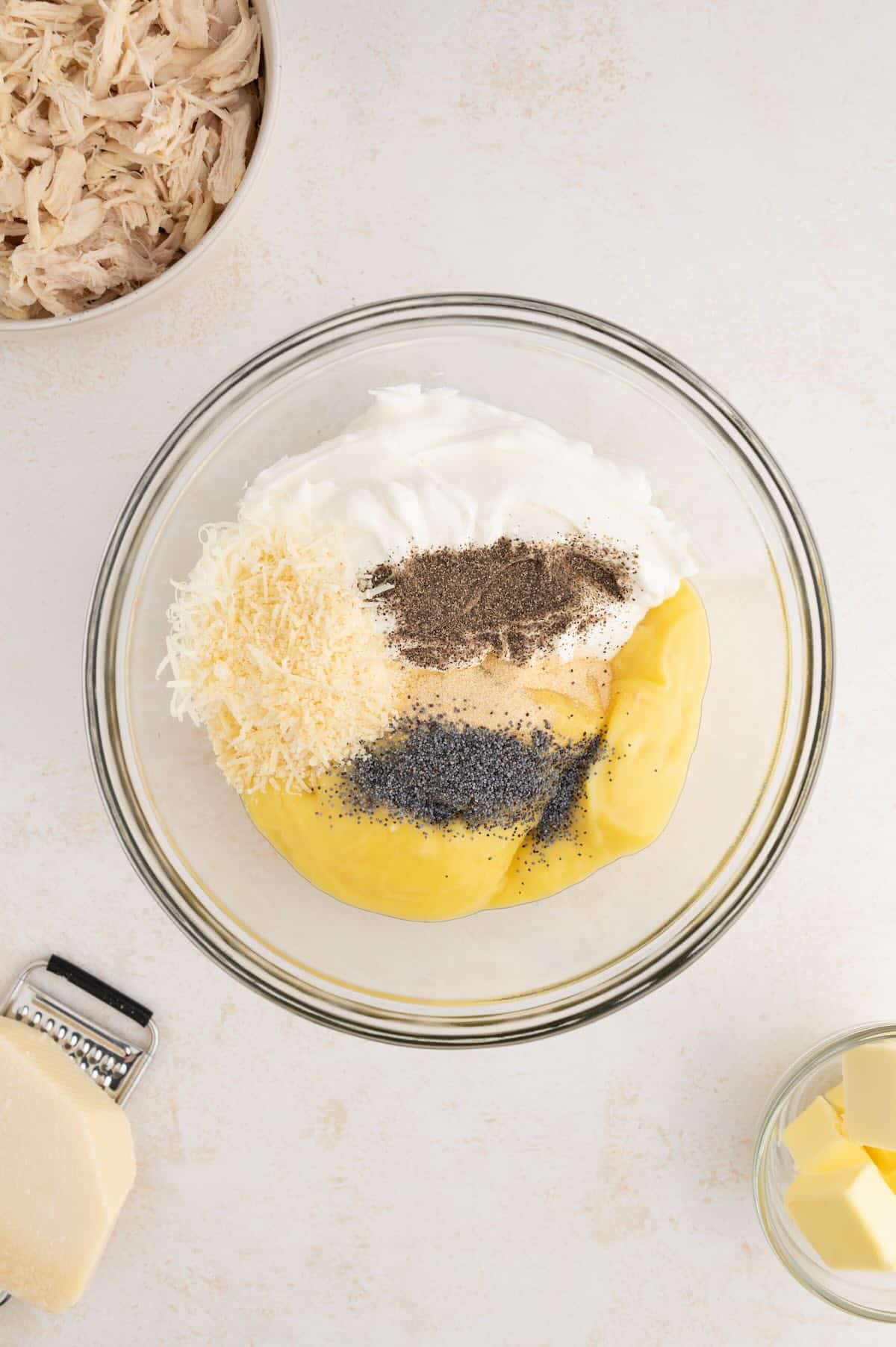 Mixing the creamy chicken and sour cream filling for poppy seed chicken casserole in a large bowl.