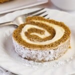 A slice of rolled pumpkin cake with cream cheese filling.