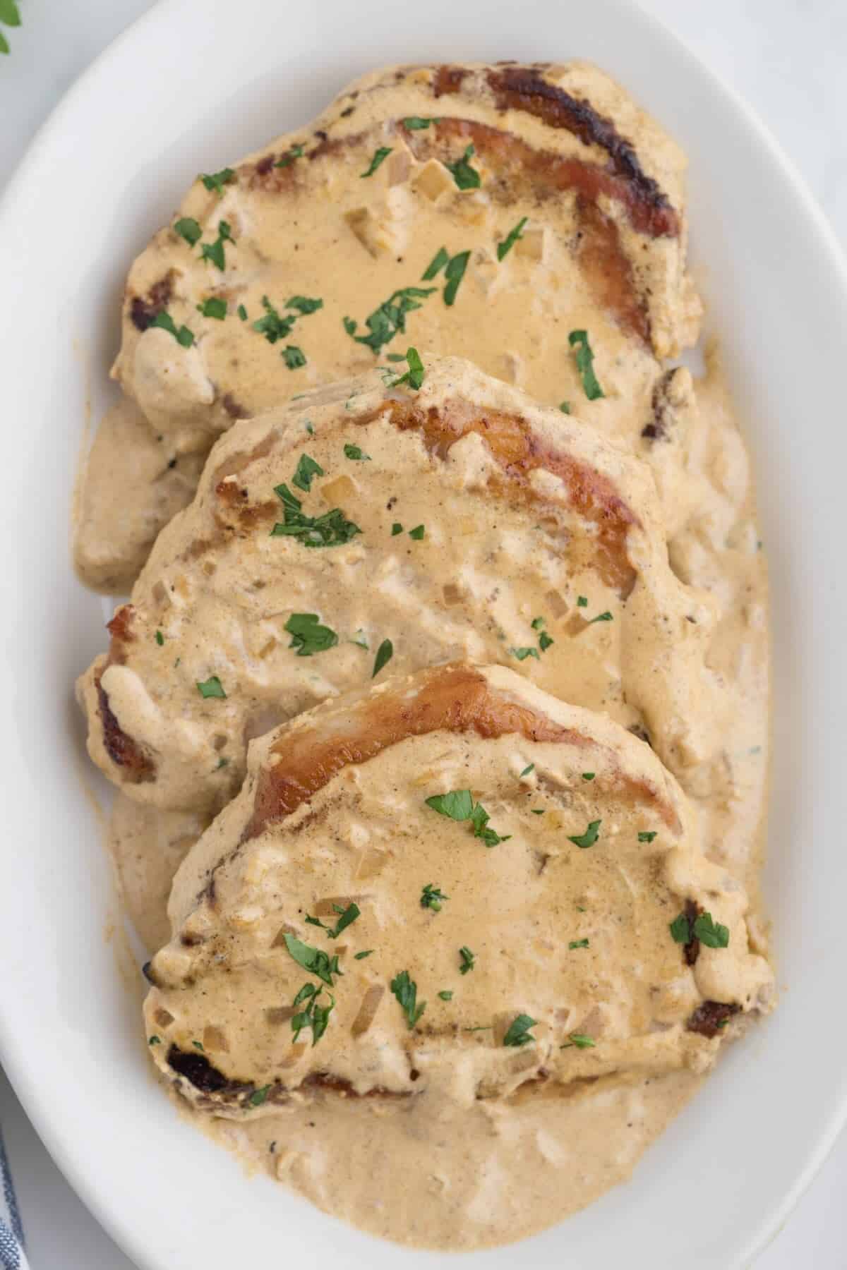 Plated smothered pork chops on a platter.