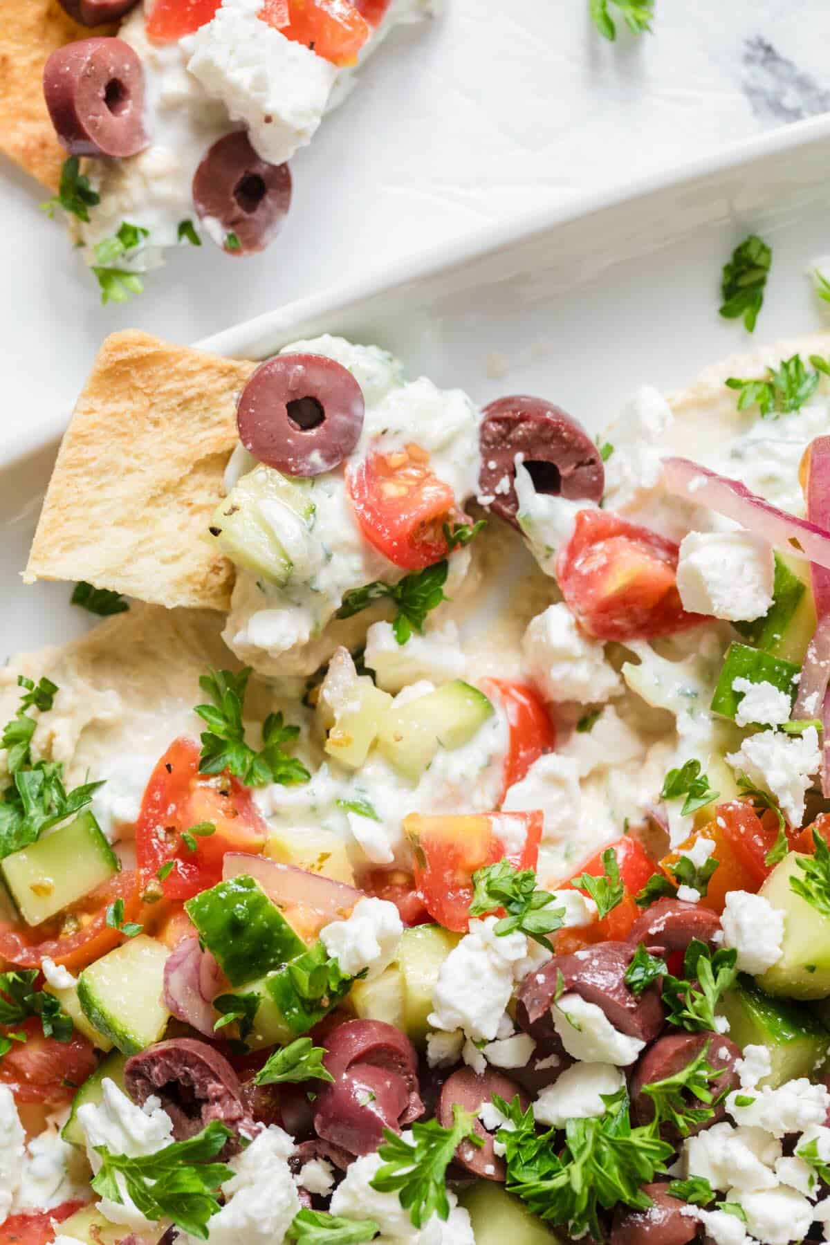 Greek layered hummus dip on a platter.