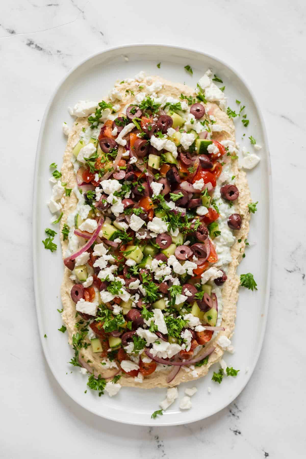 A healthy hummus dip with vegetables, Greek spices and feta cheese.
