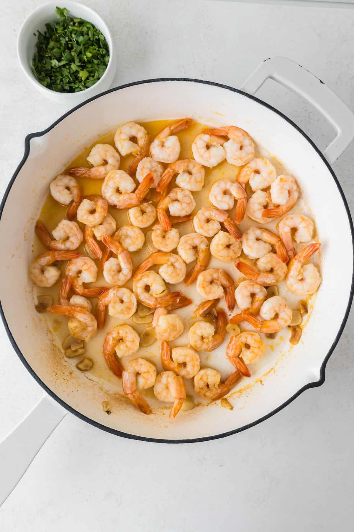 Olive oil cooked shrimp in a skillet.