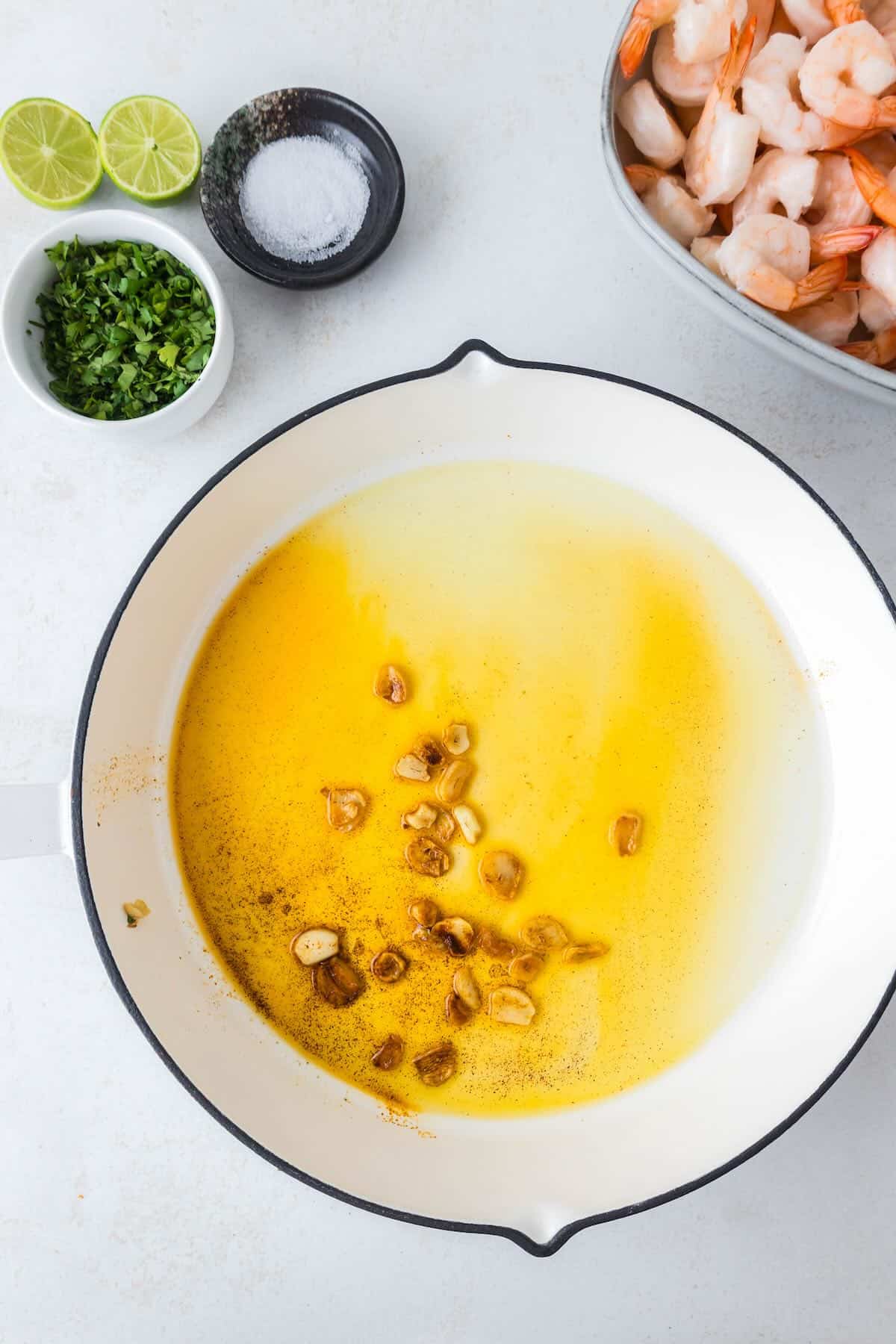 A pan with olive oil and sliced garlic.