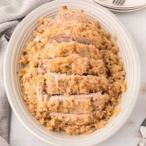 A plate of cooked roast pork and sauerkraut.