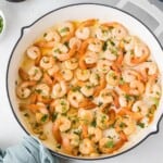 Cooked shrimp in a skillet with garlic and parsley.