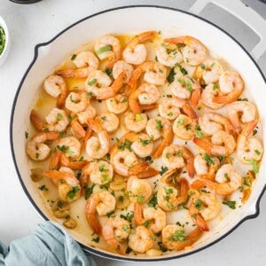 Cooked shrimp in a skillet with garlic and parsley.