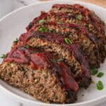 Juicy, golden-brown air fryer meatloaf topped with a sweet and tangy glaze, sliced on a plate.