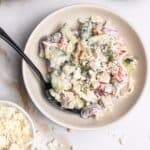 Mediterranean tuna salad in a bowl garnished with extra feta and dill.