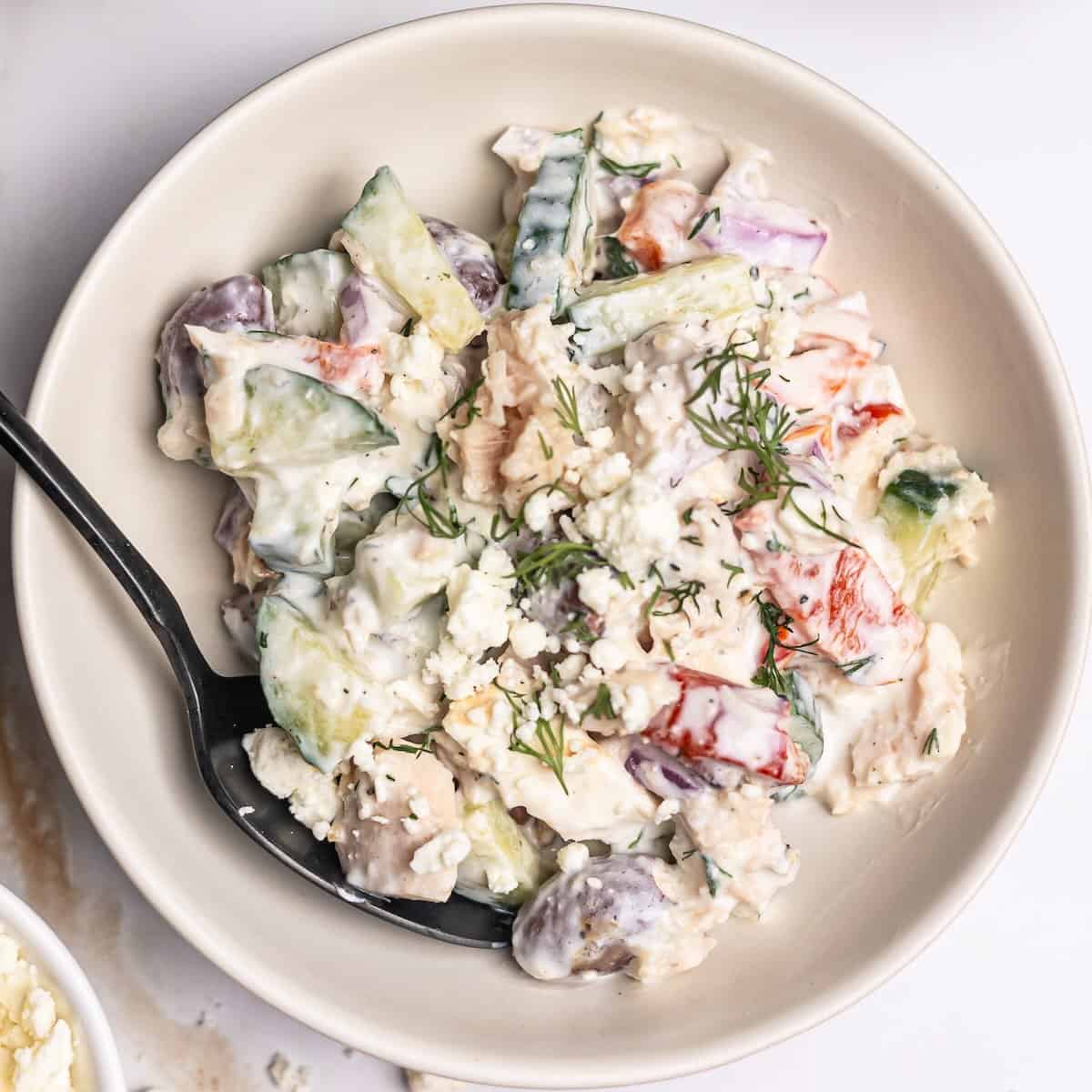 A bowl of Mediterranean tuna salad made with Greek yogurt, feta cheese, kalamata olives, and fresh dill.