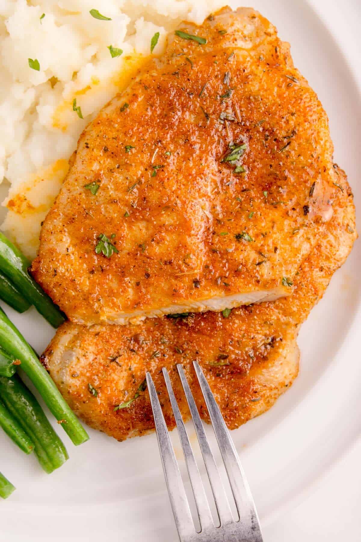 Juicy pork chops, resting on a plate.