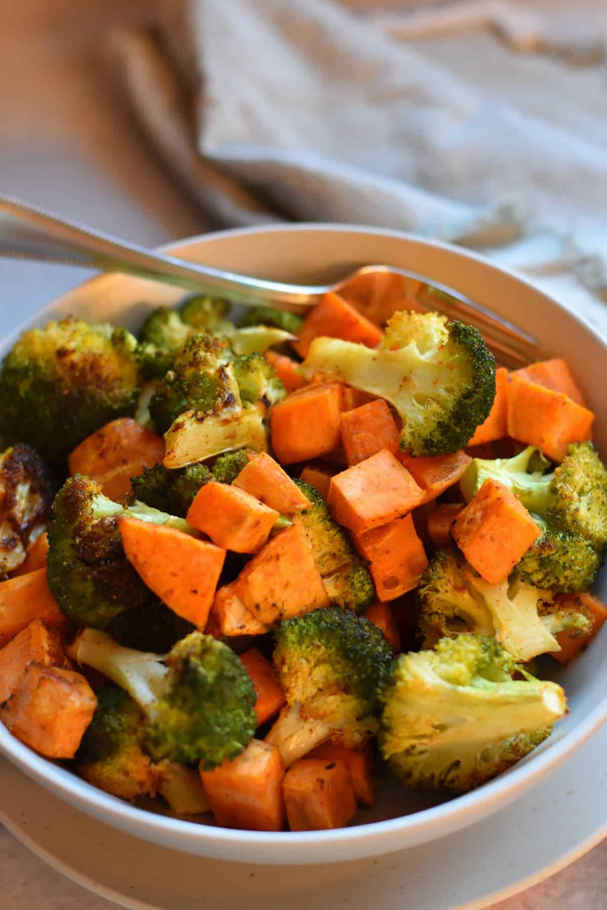 Easy roasted sweet potatoes and broccoli served in a bowl, ready to eat.
