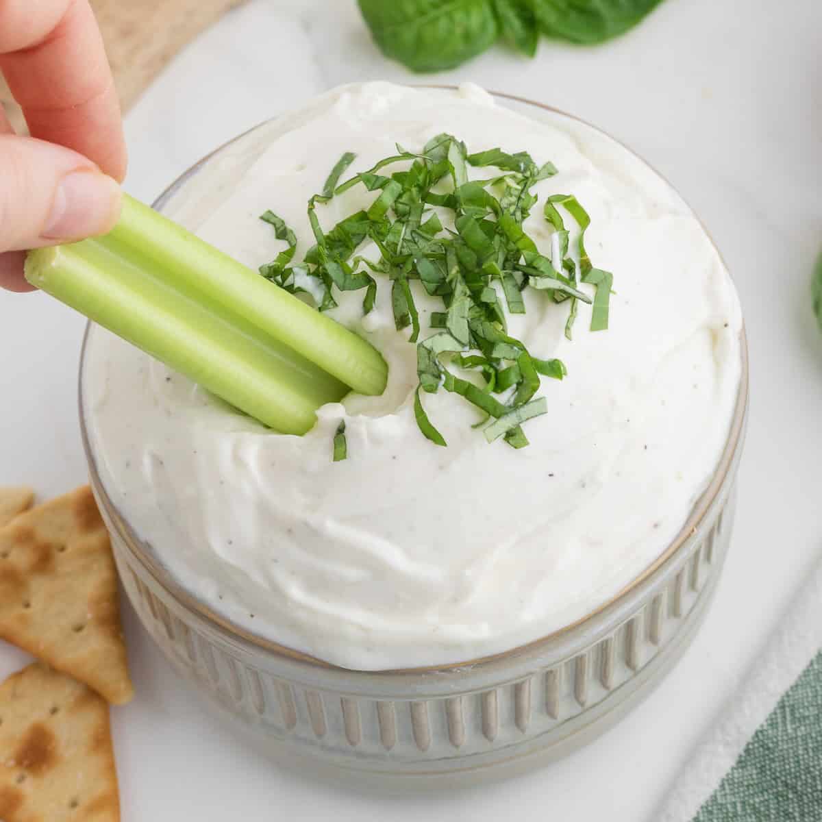 Celery dipped in a creamy cottage cheese dip topped with basil.