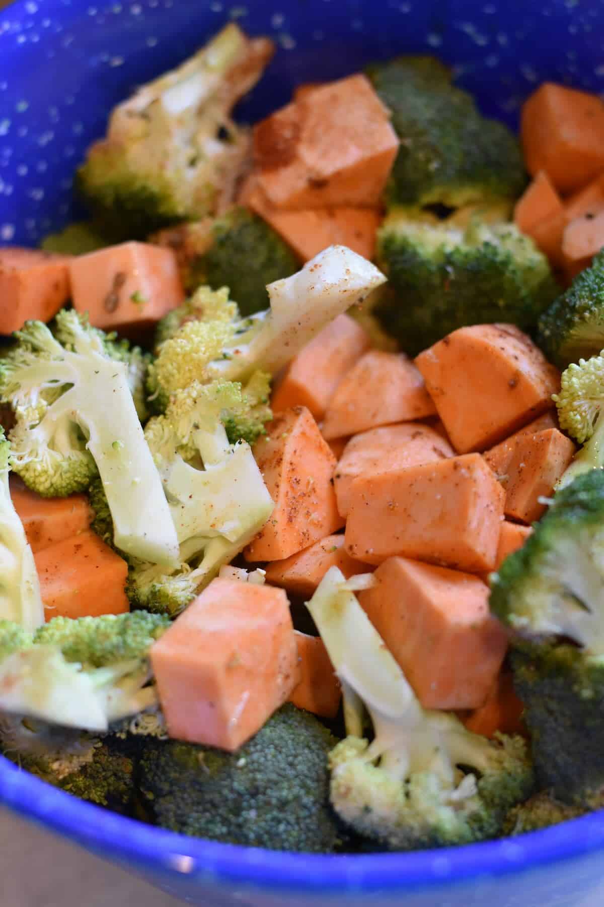 Broccoli and sweet potatoes drizzled with olive oil and sprinkled with spices.