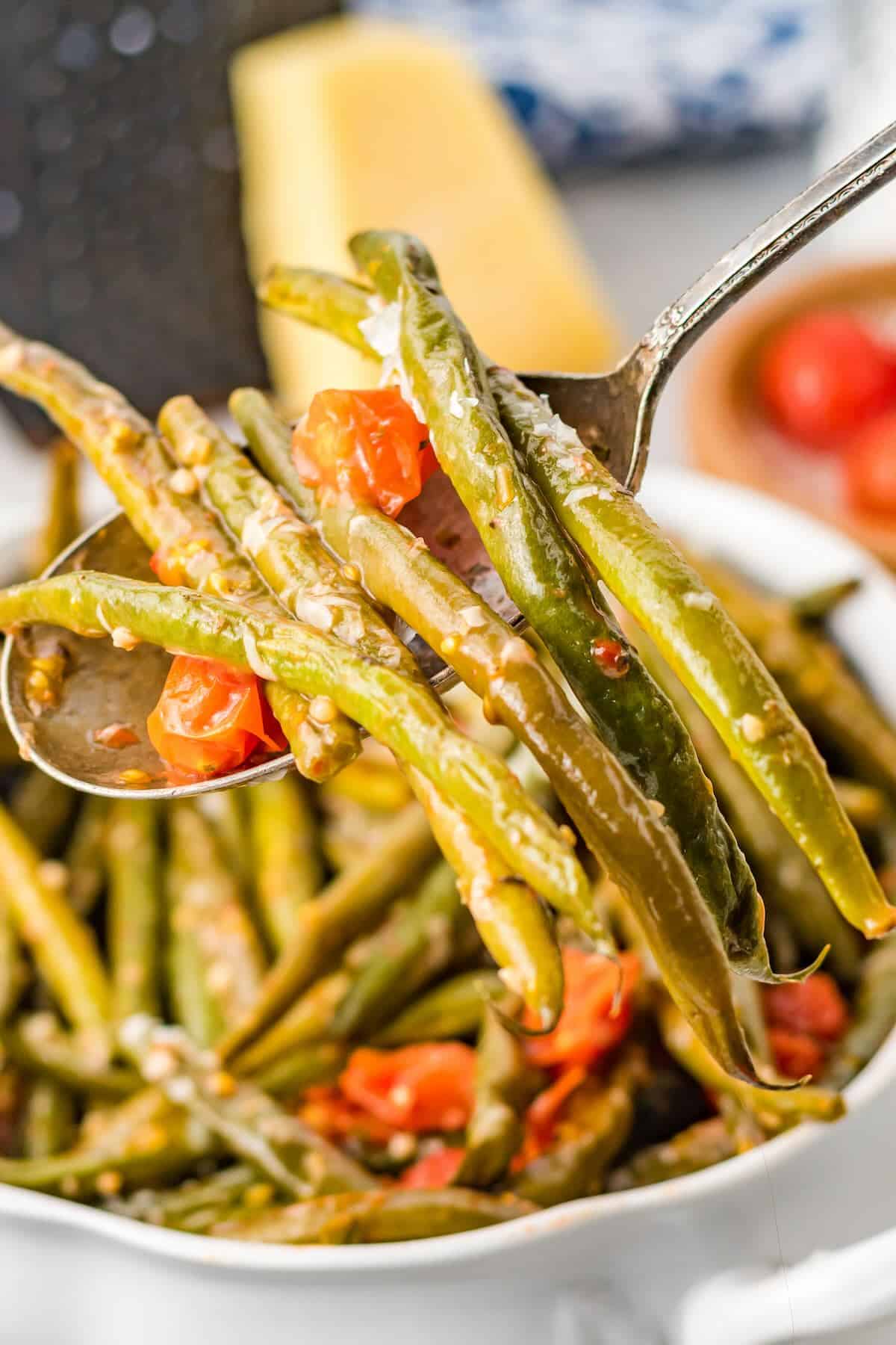 Bowl of easy Italian green beans with tomatoes and Parmesan, served as a colorful side dish.