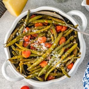 Bowl of easy Italian green beans with tomatoes and Parmesan, served as a colorful side dish.