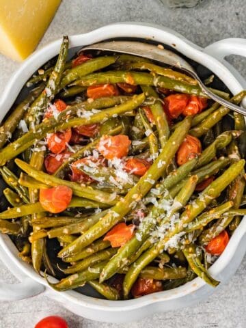 Bowl of easy Italian green beans with tomatoes and Parmesan, served as a colorful side dish.