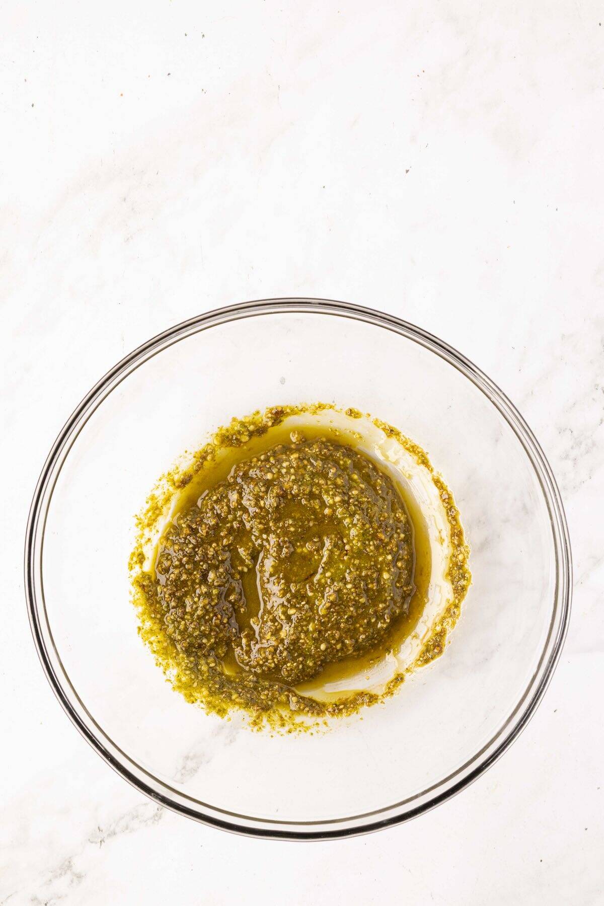 A mixture of pesto and balsamic glaze in a bowl.