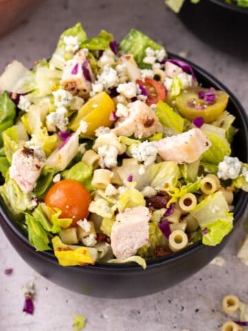 A salad bowl of Portillo's chopped salad topped with cheese.
