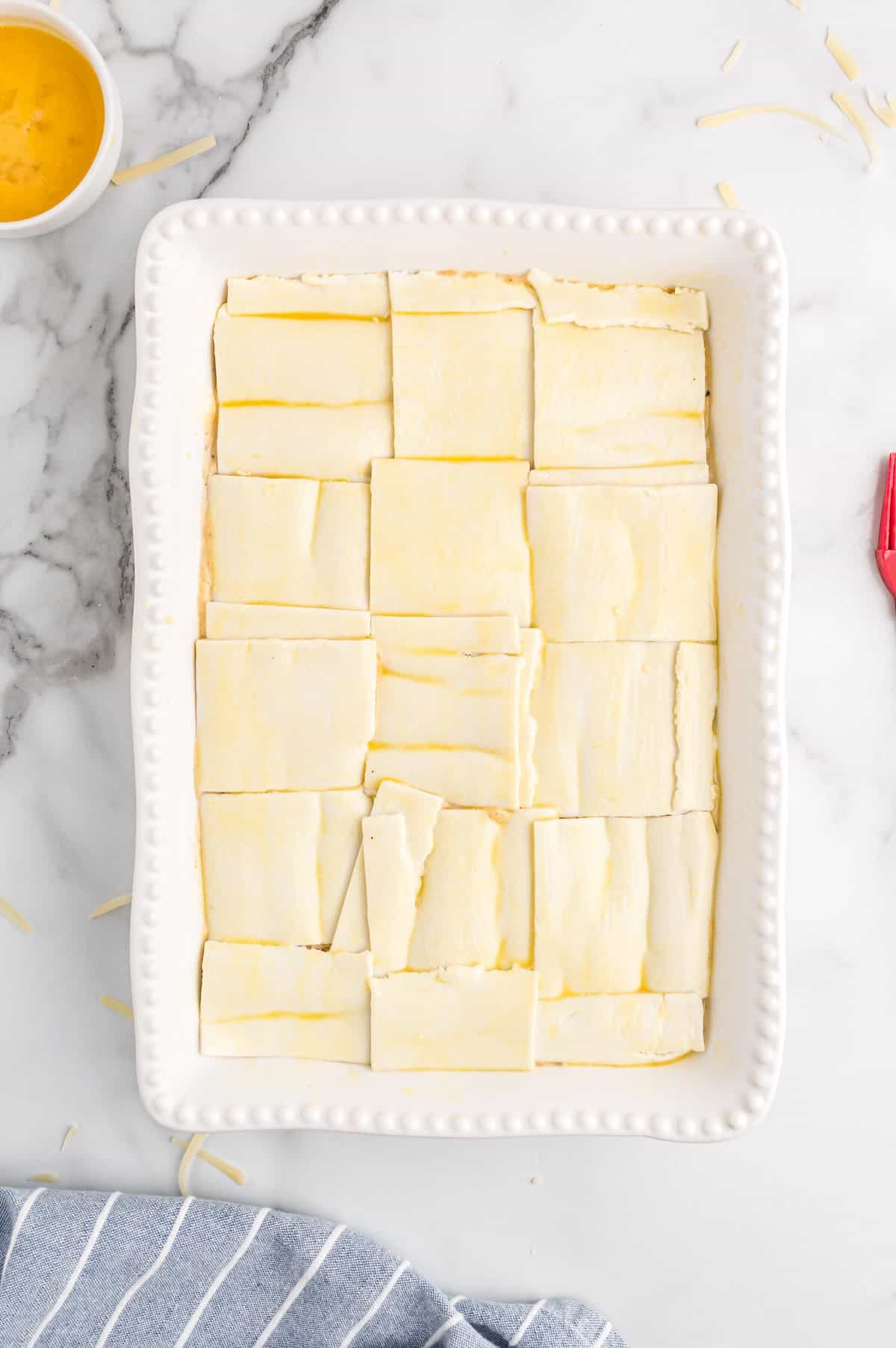 Puff pastry squares arranged on top of the chicken filling before baking.