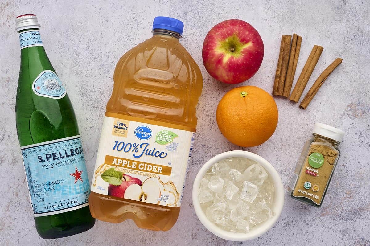 Ingredients to make apple cider punch with sparkling water, cinnamon and ginger.