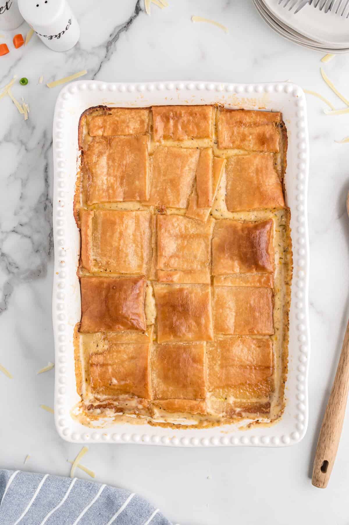 Golden brown baked chicken pot pie with puff pastry in a 9x13 casserole dish.