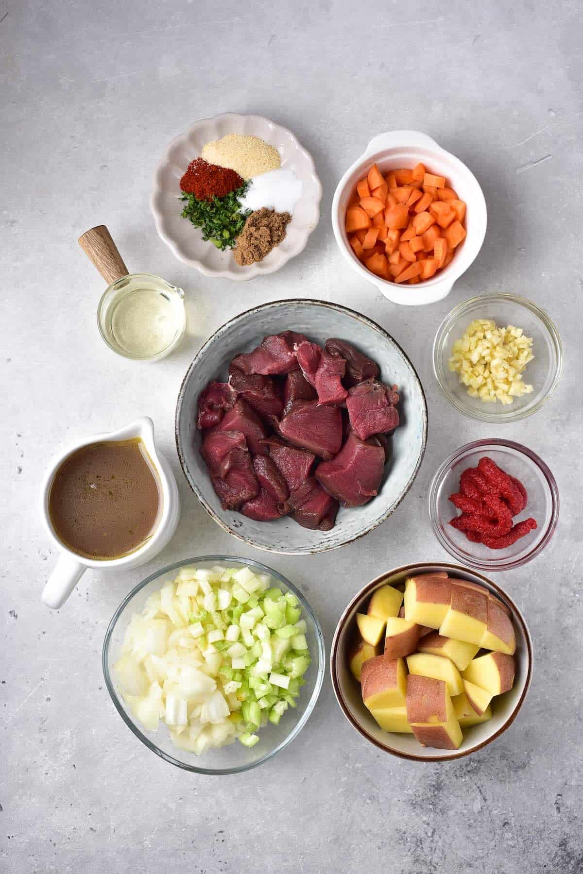 Ingredients to make venison stew in a Dutch oven.
