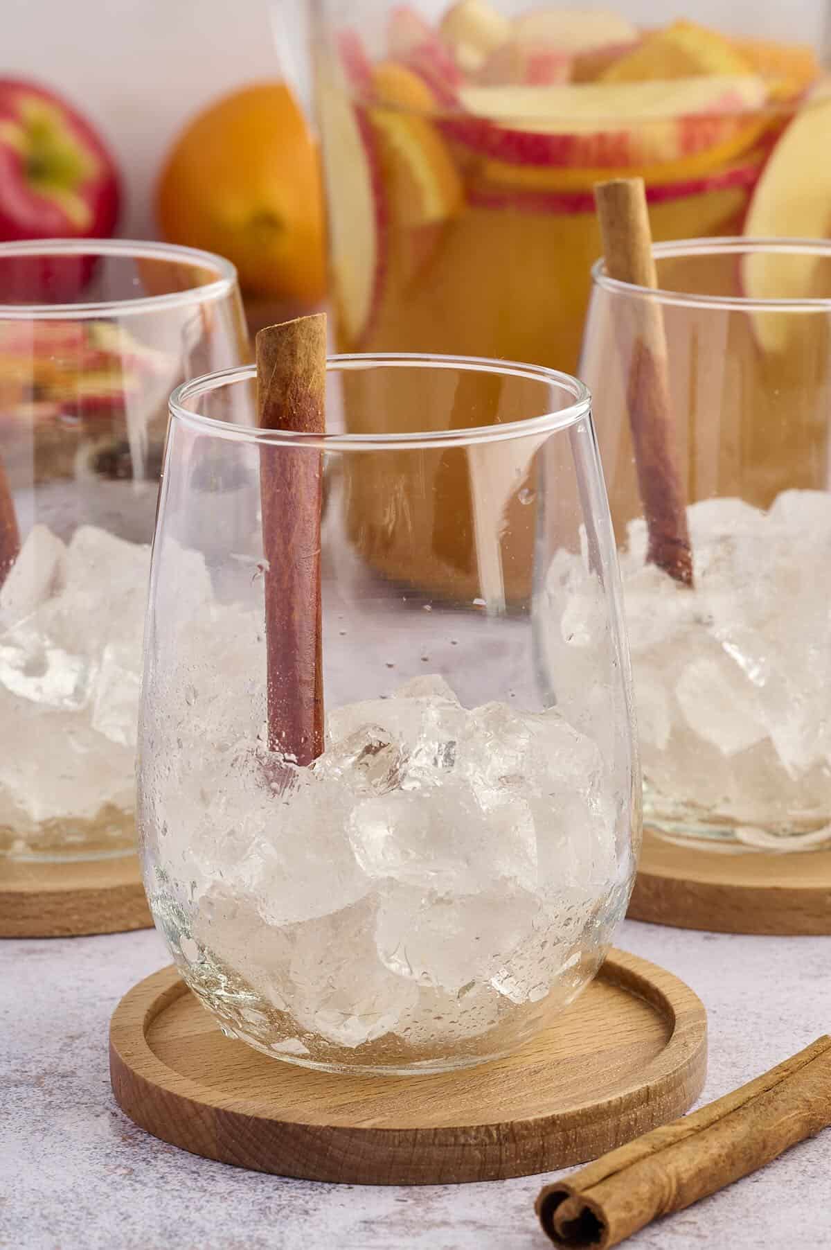 A punch glass filled with ice and garnished with a cinnamon stick.