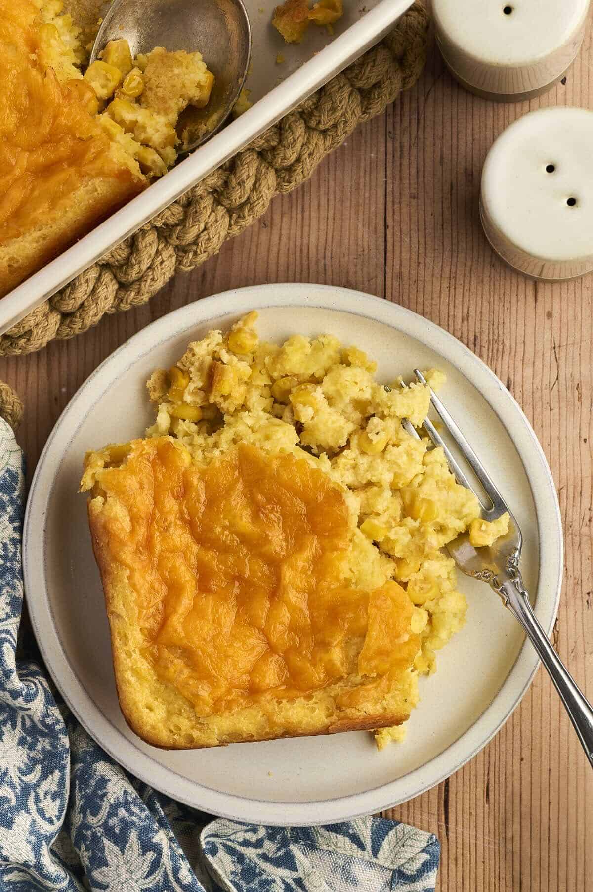 Overhead view of cheesy corn casserole with golden melted cheese on top.