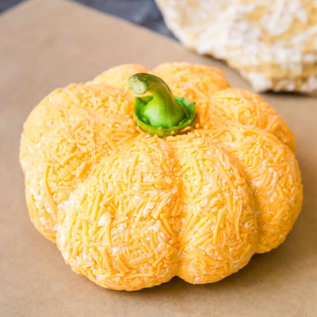 A cheddar ranch cheese ball shaped like a pumpkin.
